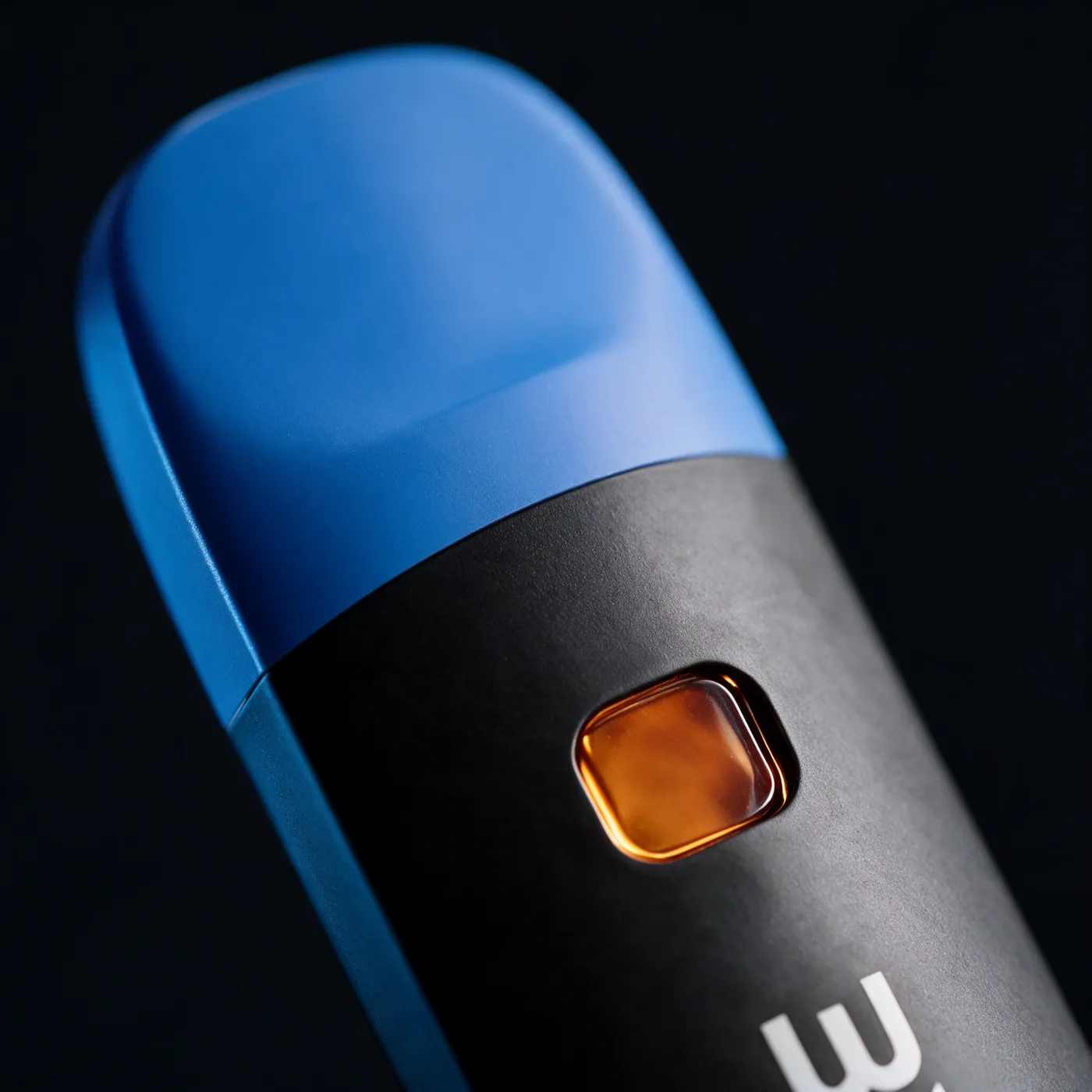 Close view of a blue-capped ZMOKE disposable vape with its amber oil window against a dark background