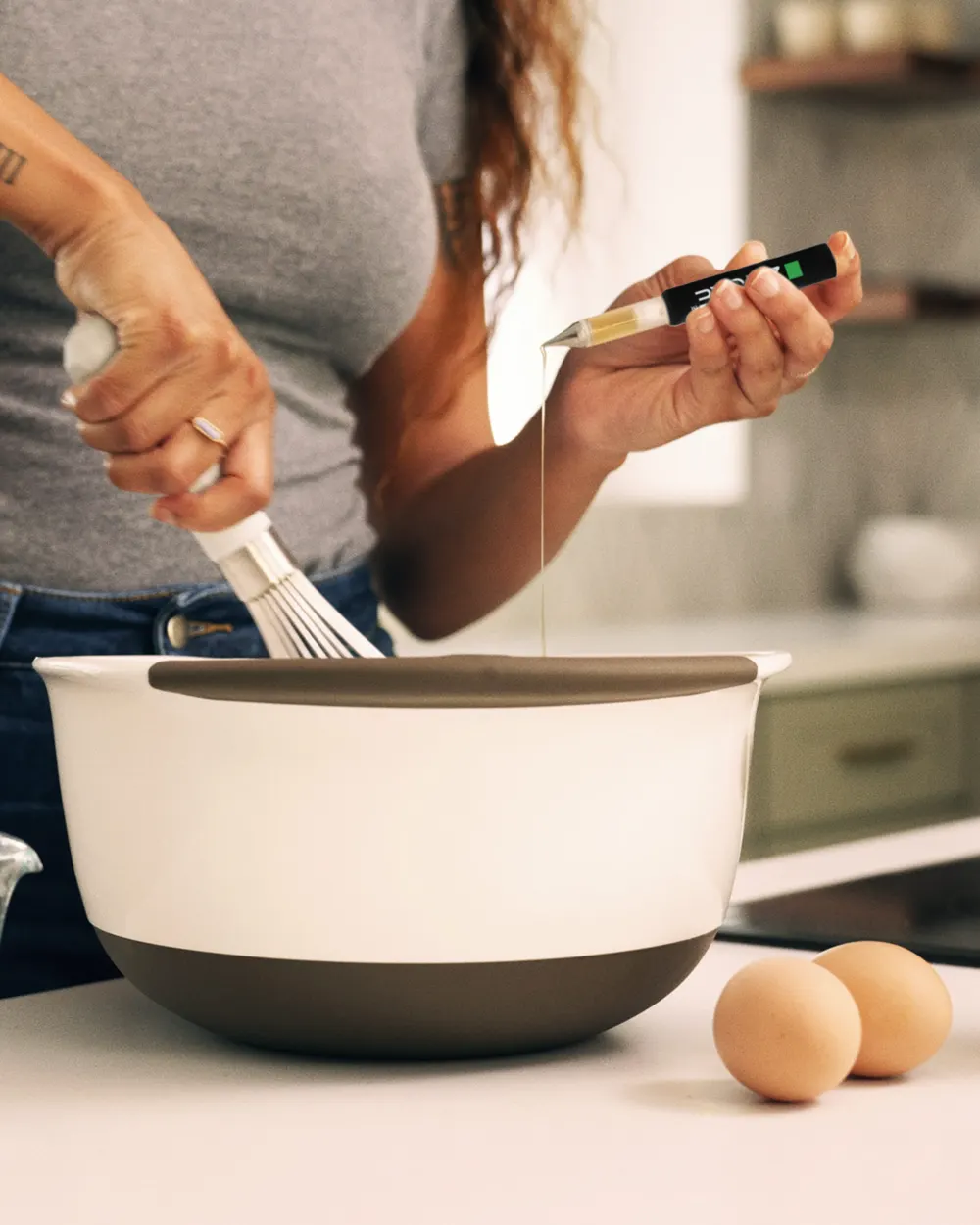 A ZMOKE applicator releasing concentrate into a mixing bowl of batter